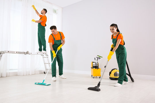 Team Of Professional Janitors Cleaning Room After Renovation