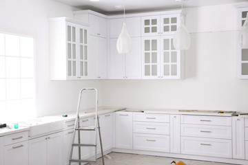 Renovated kitchen interior with stylish furniture and maintenance equipment