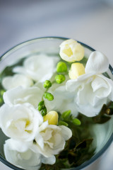 Obraz na płótnie Canvas white freesia flowers in a glass