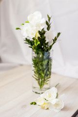 white freesia flowers in a glass