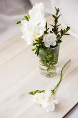 Obraz na płótnie Canvas white freesia flowers in a glass