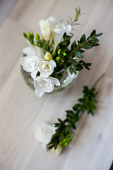Obraz na płótnie Canvas white freesia flowers in a spherical glass vase