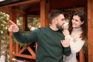 Happy couple in warm clothes outdoors. Winter vacation
