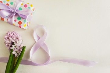 Ribbon as a symbol on March 8, spring flowers and a gift for Women's Day