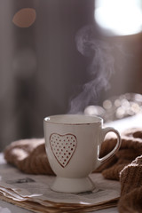 Delicious morning coffee, newspaper and knitted sweater on white table indoors