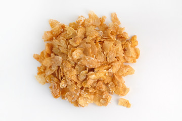 Dry corn flakes top view. Thin cornflakes in glaze on a white background. Quick breakfast cereals.
