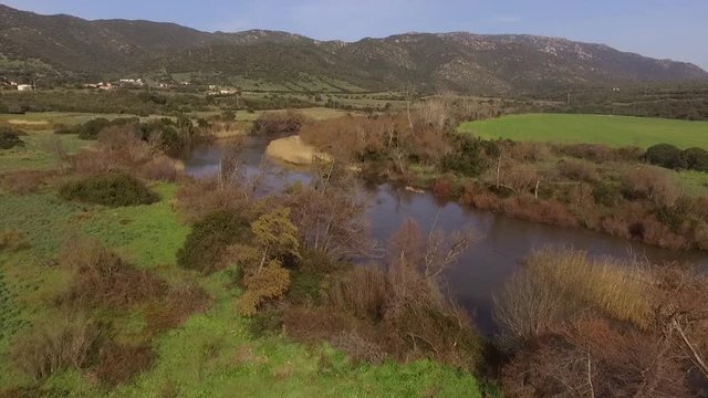 aerial view of the overflight of the lake and coghinas river in sardinia wrapped in trees and agricultural fields with the drone