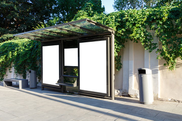 Billboard at the bus stop. Behind the wall is decorated with climbing plants. Mock up.