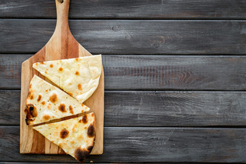 Make focaccia. Traditional italian bread on cutting board on dark wooden table top-down copy space