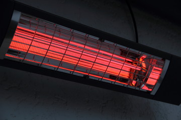 a switched on infrared heater on a house wall