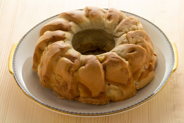 Homemade cakes, round Apple pie on a white dish. Wooden table.