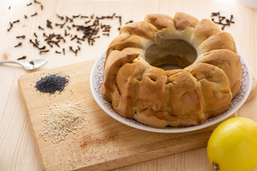 Hand-made fresh apple pie sprinkled with cinnamon. Near lemon, sesame seeds, poppy seeds. In the background, scattered carnation.