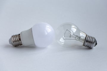 Led and incandescent lamp on a light background, close-up.