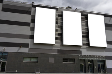 Three vertical billboards on the shopping center building. Mock-up.