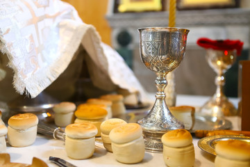 The liturgical liturgical bread of Prosphorus, Prosphora used during Orthodox worship. Preparation for Holy Communion. hands of the priest, icons placed on the altar of the Orthodox Church. The concep