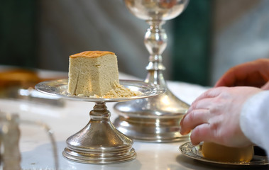 Fototapeta na wymiar The liturgical liturgical bread of Prosphorus, Prosphora used during Orthodox worship. Preparation for Holy Communion. hands of the priest, icons placed on the altar of the Orthodox Church. The concep