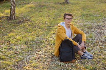 student in the park sits on the grass