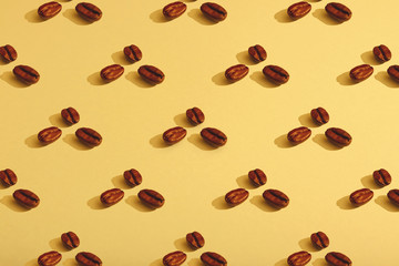 Coffee beans on yellow background. Flat lay, hard light.