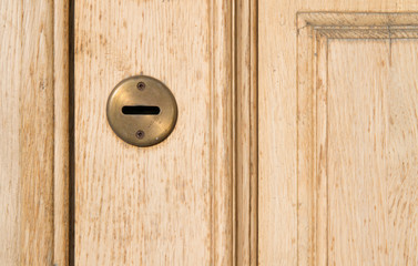 Flat keyhole on an old tan shabby retro door. Vintage beige peach color door with a horizontal...