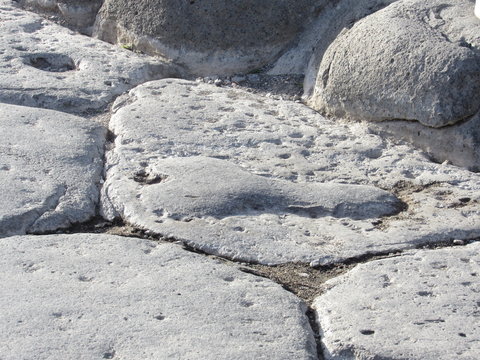 Phallic shaped carving on the road in Pompeii, Italy pointing the way to the brothel 