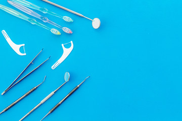 Dental care concept. Stomatological tools frame - with floss - on blue background top-down frame...