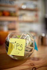 Money in the jar. Tips for a employee in coffee shop.