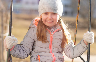 Beatiful kid swinging at swing at holidays