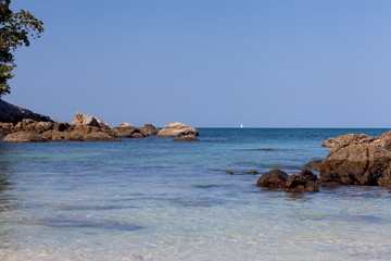 White sail on the horizon of the blue sea.