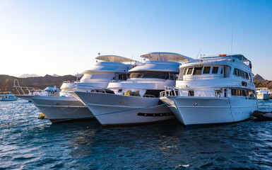 Fototapeta na wymiar Three large white yachts on the sea off the coast