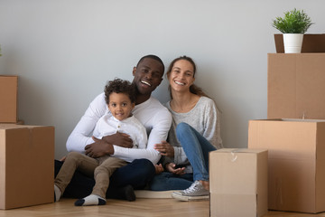Portrait happy African American family with boxes in new apartment