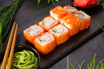 Set of sushi rolls with wasabi and ginger on a black background. Japanese oriental cuisine