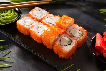 Set of sushi rolls with wasabi and ginger on a black background. Japanese oriental cuisine