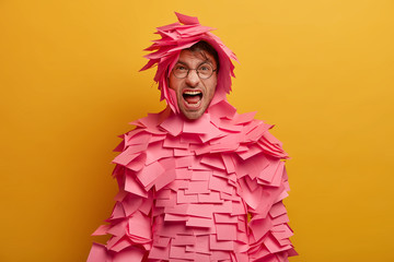 Irritated displeased man shouts angrily, expresses negative emotions, keeps mouth widely opened,...