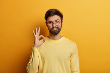 Count on me. Assertive serious looking bearded man shows okay or great sign, gives approval, looks...