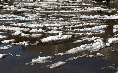 Slush.Spring.Asphalt road covered with melting snow and mud on an early spring day.Snow on the road with an admixture of dirt. The road is not cleared of snow. spring thaw. snow melting.