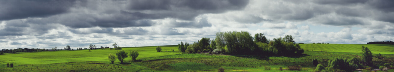 Fototapeta na wymiar Dark clouds over the green fields