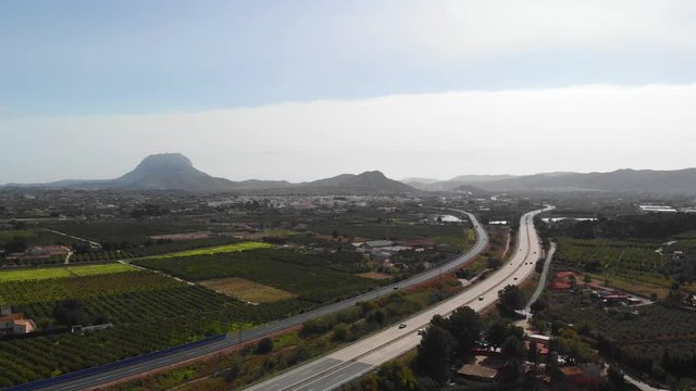 Aerial view of the AP7 highway in the cities of Ondara and Denia, Spain. Montgo mountain is in the background.
