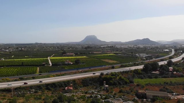 Aerial view of the AP7 highway in the cities of Ondara and Denia, Spain. Montgo mountain is in the background.