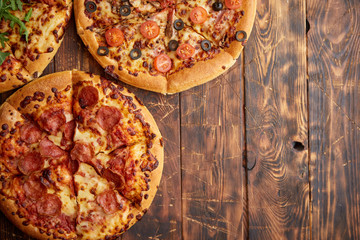 Composition of three various kinds pizzas on wooden table