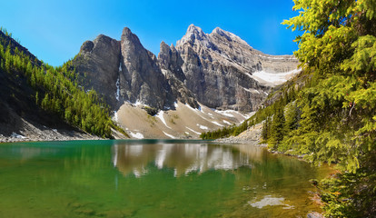 Emerald lake in high mountains water reflection alpine scenery