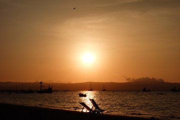 sunset reflecting on the sea. Boats in the beach of Paracas/Peru.