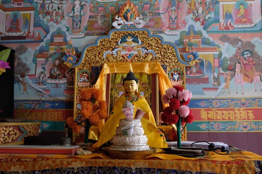 Buddha figurine and pictures on wall at the Gompa Monastery in Upper Pisang, Himalaya, Nepal. During trekking around Annapurna, Annapurna Circuit