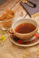 tazza di te nero con biscotti al cioccolato su tavolo di legno