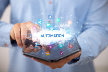 Businessman holding a foldable smartphone with AUTOMATION inscription, technology concept