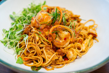 Tasty appetizing spaghetti pasta with prawns and salmon roe in Thai style.