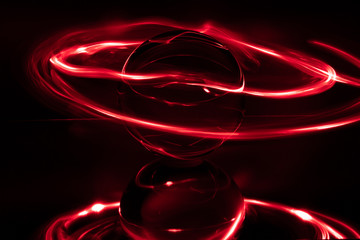 some red rings surround a crystal clear glass ball on a mirror