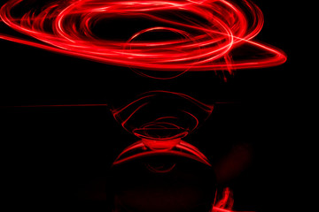 some red rings surround a crystal clear glass ball on a mirror