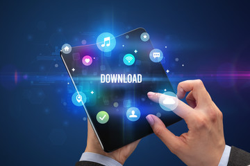 Businessman holding a foldable smartphone with DOWNLOAD inscription, social media concept