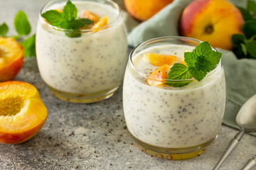 Natural detox, fruit dessert close-up, healthy dieting concept. Peach Yogurt smoothie or milk shake with chia seeds in glass jar on a stone concrete worktop.