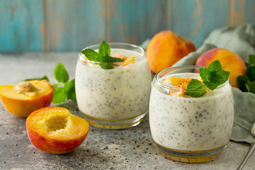 Natural detox, fruit dessert, healthy dieting concept. Peach Yogurt smoothie or milk shake with chia seeds in glass jar on a stone concrete worktop. Copy space.